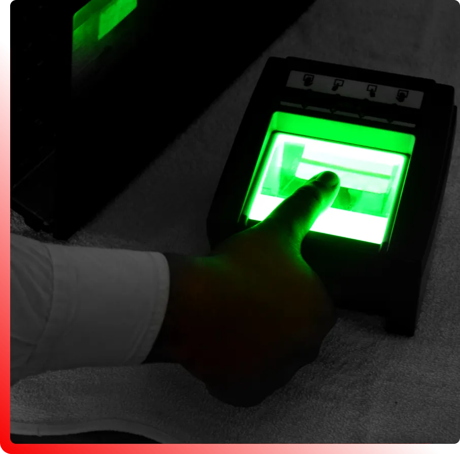 A hand pressing on a fingerprint scanner that is glowing green.